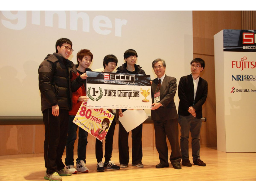 優勝チーム「TOEFL Beginner」を祝福するSECCON実行委員の佐々木良一 東京電機大学 教授