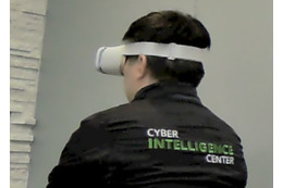 記者会見準備中に VR ヘッドセットをつけて何か作業をしていたセンタースタッフ、身にまとっているのは eCIC のスタッフジャンパー
