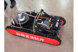 消防庁は、災害救助用走行ロボットのデモを実施。PTZカメラ、高輝度LED照明を搭載。本体はIP67構造で、水深1mにも対応