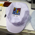 作業者の帽子などに印刷されたカラーバーコード「カメレオンコード」により入退室を監視。カメレオンコードはCMYKの4色で構成され、ブロック数の増減でデータ量は可変。作業者の個別管理には十分な情報量を持つ。