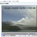 本村西の望遠監視カメラからは湾越しに新岳の様子を確認することが可能（画像は気象庁火山カメラの映像より）。