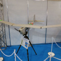 「ワイヤレスジャパン2015」のNICTブースに展示されていた小型無人飛行機は翼長約2.8m，重量約6Kg、連続飛行時間は2～3時間程度。2GHz帯を使用し通信可能区域は約15Kmとなっている（撮影：編集部）