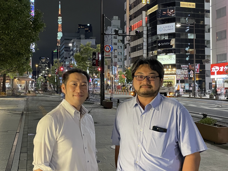 東京タワーの夜景を背景にたたずむ「あつまれ！X.1060ピーポー」に登壇する武井氏(左)と「あつまれ！セキュリティ運用ピーポー」に登壇する井上氏(右)