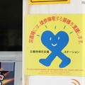 道中のカラオケ店に貼られていた「災害時帰宅支援ステーション」を示すマーク。災害時には、トイレや水道を借りることができる施設の目安となる（撮影：防犯システム取材班）