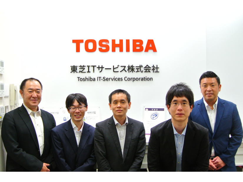 東芝ITサービス株式会社 サービス商品・技術開発部 営業技術・人財開発担当 主幹 金田 明宏 氏（左端）、サポート&ソリューション統括部 ソリューション推進部 セキュリティビジネス推進担当 グループ長 佐々木 尚仁 氏（右端）、同推進部 セキュリティビジネス推進担当 主任 平林 康博 氏（中央）、同推進部  セキュリティビジネス推進担当 齋藤 渉 氏（左から二番目）、同推進部 セキュリティビジネス推進担当 杉原 大和 氏（右から二番目）